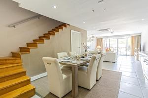 棕榈滩Large Luxury apartment on Palm Beach的一间带桌椅和楼梯的用餐室