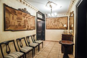克拉约瓦Veritas Boutique Vila的一间设有椅子的房间和墙上的绘画