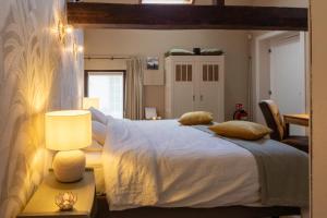 Leuze-en-HainautLa Bergerie的卧室配有一张带灯的白色大床