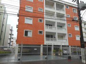 瓜鲁雅apartamento fofo Astúrias的一座红砖建筑,设有白色阳台