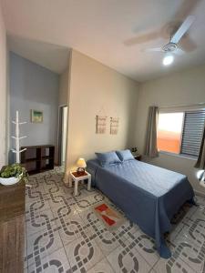 佩鲁伊比No Centro a 3 min da praia, Pet Friendly e Wi Fi的一间卧室设有蓝色的床和窗户。