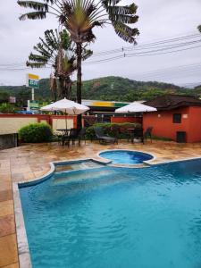 朱奎Apto Duplex com Mezanino的一座带桌子和遮阳伞的游泳池位于一座建筑旁边