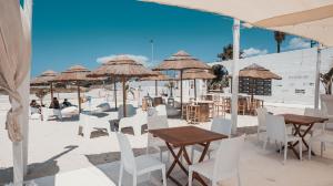 托雷圣乔万尼乌Villaggio Poseidone Beach Resort - Hotel的一个带桌椅和遮阳伞的海滩