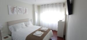 维戈Val do Fragoso的卧室配有一张白色床,上面有两根纸巾