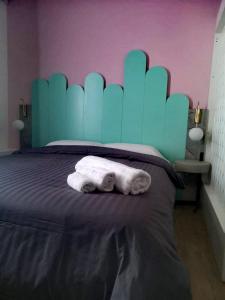 尼科西亚Unique City Centre Apartments的一张带蓝色床头板的床和两条毛巾