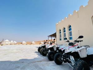 Dream Desert Camp的停在建筑物旁边的一排摩托车