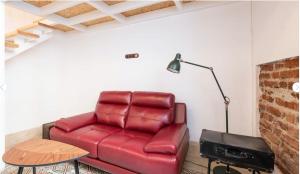 圣克鲁斯-德特内里费Casa Guadalupe y Roque的客厅里一张红色的皮沙发,配有灯