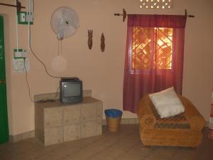 SukutaCamping-Sukuta & Lodge的客厅配有电视、椅子和风扇