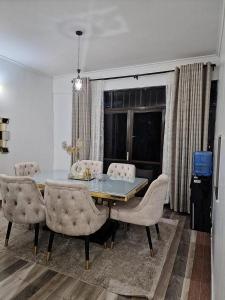 基苏木3 BDR Luxurious Villa in Milimani Kisumu的一间带桌子和椅子的用餐室