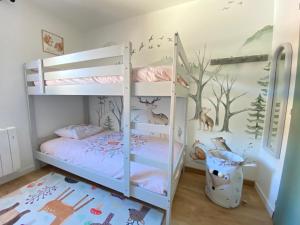 土绪尔Grand T3- pied des pistes-63 m2-8 personnes的一间卧室设有两张双层床和一幅木画