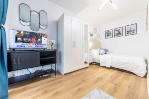 Évry-les-ChâteauxAppartement en face gare d'Evry - Proche Paris & Disney - Easy check in - Arrivée autonome -Place de parking privative - Wifi的一间卧室配有一张床和一台平面电视