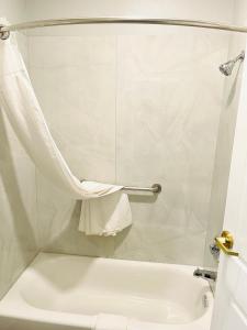 拉波特花园套房汽车旅馆的浴室配有白色浴缸和卫生间。