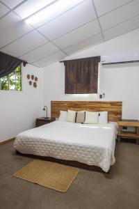 埃尔蒙特Hotel Michanti的卧室配有一张白色大床和木制床头板