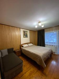 亚列姆切Котедж ''Олечка''的一间卧室配有一张床、一张沙发和一个窗口