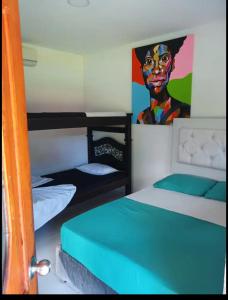 比亚维森西奥HOSPEDAJE FAMILAR CAMPESTRE "Villa Alondra"的一间带两张双层床的卧室和一幅女画
