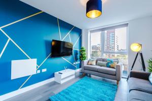 曼彻斯特Spacious 3-Bedroom Apartment in Central Manchester with Private Rooftop Terrace & Stunning City Views的蓝色的客厅配有沙发和电视