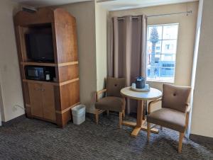 安纳海姆阿纳海姆酒店波托菲诺套房酒店的配有桌椅和电视的客房