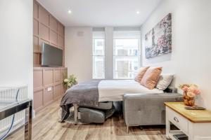 伦敦Bright & Modern 2-Bed Notting Hill Apartment的一间卧室配有一张床和一台电视