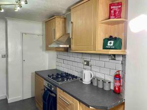 查塔姆Home In Medway的厨房配有木制橱柜和炉灶烤箱。
