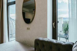 第比利斯Highgarden Hotel的一张沙发的墙上镜子