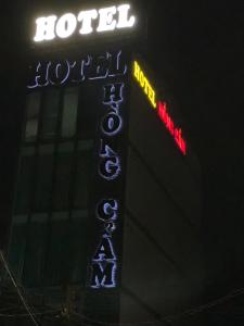 Trung AnHotel Hồng Cẩm的夜间在大楼前的酒店标志