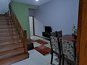 安格拉杜斯雷斯Casa aconchego Parque Mambucaba的客厅设有楼梯和桌椅