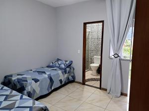 安格拉杜斯雷斯Casa aconchego Parque Mambucaba的一间卧室配有一张床,一扇门通往浴室