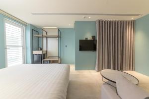 Shimen半岛海悦渡假会馆的一间卧室配有一张床、一张沙发和一台电视。