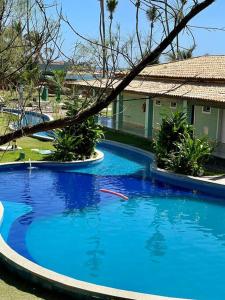 卡马萨里O Paraíso é aqui: Pé na Areia em Arembepe的一座大蓝色游泳池,位于房子前