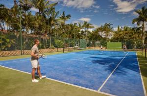 布里斯班布里斯班度假村酒店的站在网球场上,手持球拍的人
