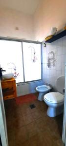 布宜诺斯艾利斯Boedo Tango的一间带两个卫生间、水槽和两个窗户的浴室