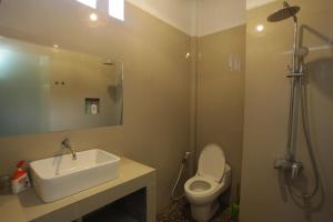 甘地达萨迪达萨休闲海滩度假酒店的一间带水槽、卫生间和淋浴的浴室