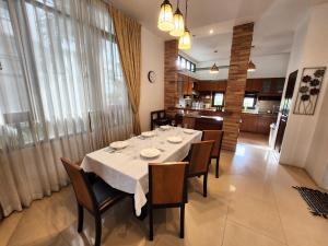 乔木提恩海滩ปุณณภา พูล วิลล่า พัทยา Punnapha Pool Villa Pattaya的一间配备有白色桌椅的用餐室