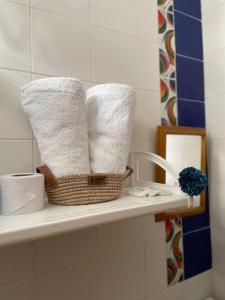 托卢Casa Inés Tolú的浴室内架子上的一篮毛巾