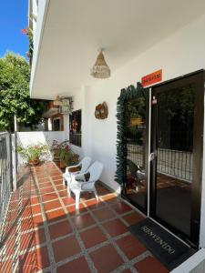 托卢Casa Inés Tolú的房屋内带两把白色椅子的庭院