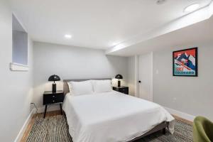 丹佛Downtown Denver Gem的卧室配有一张白色大床和一把椅子