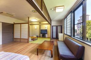 仙北龟之井酒店田泽湖的客房设有沙发、桌子和窗户。