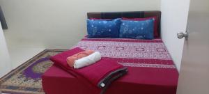 甘孟Bambob Homestay and Car Rental的一间卧室配有一张带紫色床单和蓝色枕头的床。
