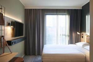切斯特Moxy Chester的酒店客房设有床和窗户。