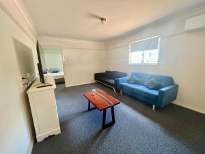 达博West View Caravanpark的客厅配有蓝色的沙发和桌子