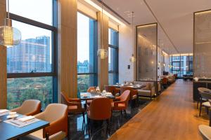 西安西安高新 JW 万豪酒店的餐厅设有桌椅和大窗户。