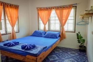 库德岛Lungkluay homestay的一间卧室配有一张带蓝色床单和橙色窗帘的床。
