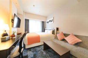 鹿儿岛QuintessaHotel KagoshimaTenmonkan Relax&Sleep的酒店客房,配有床和沙发