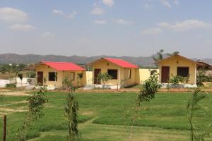 布什格尔SK Pushkar Resort的田野中一排有红色屋顶的房屋