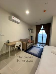 哥打京那巴鲁The Shore Kota Kinabalu by Ariana的一间卧室配有一张床、一张桌子和一张沙发