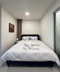 哥打京那巴鲁The Shore Kota Kinabalu by Ariana的一间卧室,卧室配有一张床,位于阿里亚海岸边