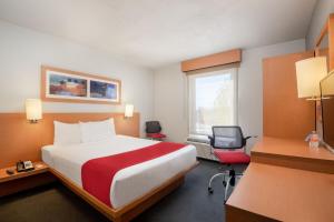 天宝佐特兰天宝佐特兰城市快捷酒店的酒店客房设有一张大床和一张书桌。