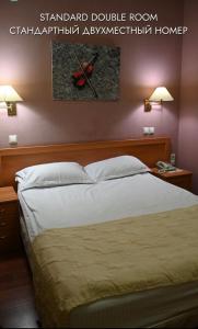 阿特劳格林酒店的卧室内的一张床位,墙上有两盏灯