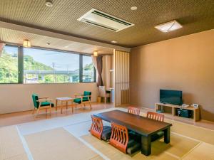 Tōna奥松島LANEホテル的客厅配有桌椅和电视。