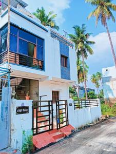 蓬蒂切里Rose Villa Pondicherry的一座棕榈树成荫的白色房子